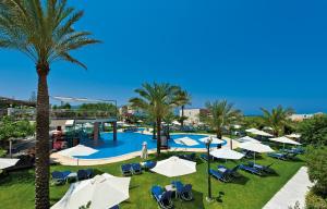 een resort met een zwembad en palmbomen en parasols bij Selini Suites & Waterpark in Kolymvari