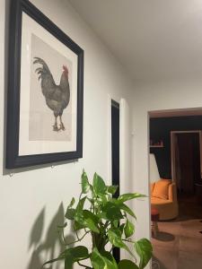 Cosy Colour Place في فيليرز سور مارن: صورة لدجاج على جدار مع نبات