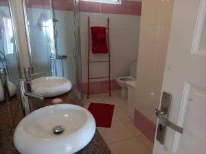 La salle de bains est pourvue de 2 lavabos, d'une douche et de toilettes. dans l'établissement Villa mangue Julie, à Trois-Rivières