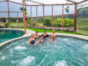 a group of people in a swimming pool at Orquideas Runtun in Baños