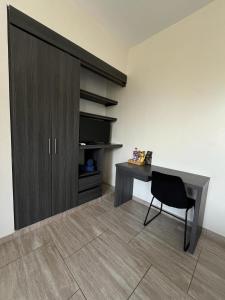 Zimmer mit einem Schreibtisch, einem Schrank und einem Stuhl in der Unterkunft HOTEL LE FALEP in Anapoima