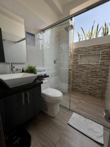 y baño con aseo, lavabo y ducha. en HOTEL LE FALEP, en Anapoima