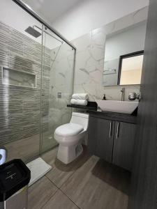 La salle de bains est pourvue de toilettes, d'un lavabo et d'un miroir. dans l'établissement HOTEL LE FALEP, à Anapoima