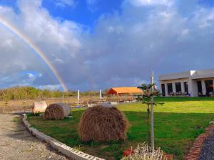 a rainbow over a field with hay bales at 隱月民宿 in Hengchun South Gate