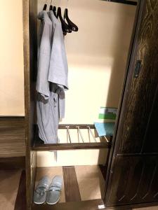 a closet with two pairs of shoes and towels at Ruean Phae Royal Park Hotel in Phitsanulok