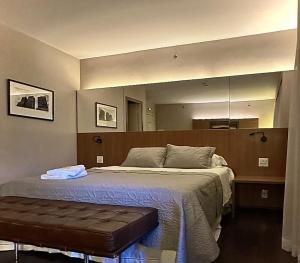 a bedroom with a bed and a large mirror at Romastay Itaim SP in Sao Paulo