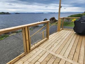 a wooden deck with a view of the water at Seaclusion Twillingate in Twillingate