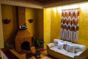 a living room with a couch and a fireplace at Casa Margarita , La fuente de la luna in Tequisquiapan