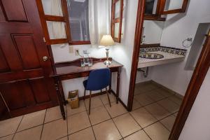 a small room with a desk and a blue chair at Las Mariposas Hotel & Studios in Oaxaca City +80 photos