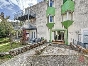 um edifício com uma varanda ao lado em Appartement Lamalou-les-Bains, 2 pièces, 2 personnes - FR-1-451-23 em Lamalou-les-Bains