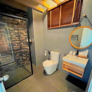a bathroom with a toilet and a sink and a mirror at COZY SHIROI RESORT in Nang Rong