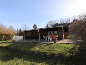 une maison avec une table et des chaises dans une cour dans l'établissement Gîte Arpajon-sur-Cère, 3 pièces, 4 personnes - FR-1-742-21, à Arpajon-sur-Cère