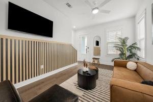 a living room with a couch and a tv on a wall at Sandy Serenity Retreat in Panama City Beach