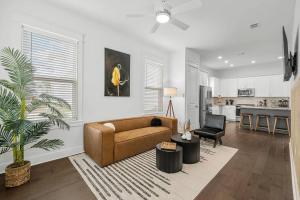 a living room with a brown couch and a kitchen at Sandy Serenity Retreat in Panama City Beach