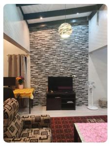 a living room with a brick wall and a tv at Seaside Homes in Nadi