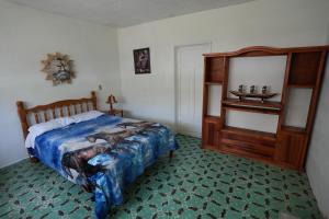 a bedroom with a bed and a table and a mirror at Hostal Casa Del Sol Comitan in Comitán de Domínguez