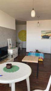 a living room with a table and a room with a bed at Sossego da Lana - vista mar in Fortaleza