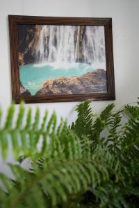 a picture of a waterfall hanging on a wall at Hostal Casa Del Sol Comitan in Comitán de Domínguez
