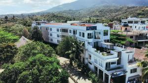 eine Luftansicht eines weißen Gebäudes mit Bäumen in der Unterkunft Casa Marco Suites Puerto Galera powered by Cocotel in Puerto Galera