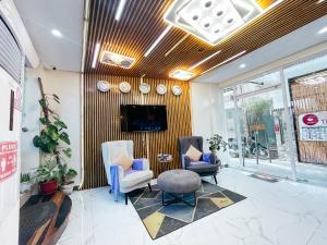 eine Lobby mit zwei Stühlen und einem Fernseher an der Wand in der Unterkunft Casa Marco Suites Puerto Galera powered by Cocotel in Puerto Galera