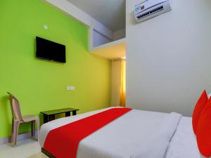 1 dormitorio con cama y pared verde en Hotel RBS NFC Road, en Maula Ali