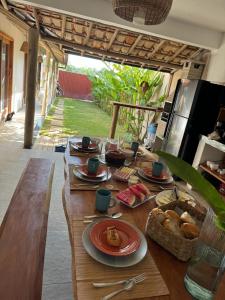 een houten tafel met borden eten erop bij Casa Vivá in Arraial d'Ajuda