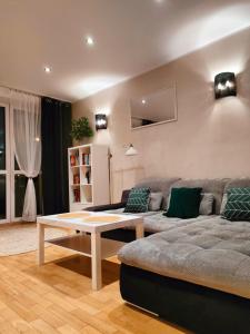ein Wohnzimmer mit einem Sofa und einem Couchtisch in der Unterkunft Apartament przy Operze in Białystok