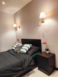 a bedroom with a bed with two pillows and a table at Apartament przy Operze in Białystok
