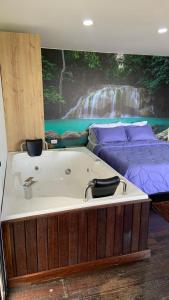 La salle de bains est pourvue d'une baignoire et d'un lit. dans l'établissement Jacaranda Glamping, à El Peñol