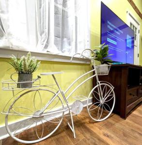 un vélo blanc garé à côté d'une table avec des plantes dans l'établissement Walkable Elmwood Cottage, No Chores 2Bath 2BR 1Car, à Buffalo