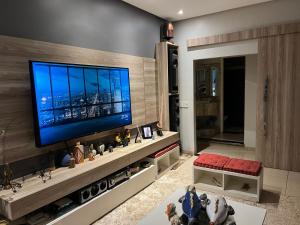 een woonkamer met een flatscreen-tv aan de muur bij ACONCHEGANTE (SUITE) in Rio Verde