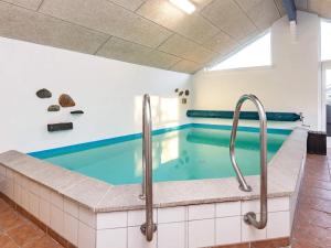 - une piscine d'eau bleue dans un bâtiment dans l'établissement 8 person holiday home in Hals, à Hals