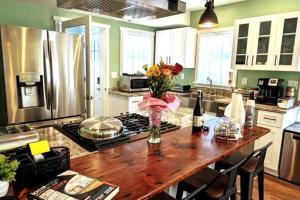 a kitchen with a wooden table with a vase of flowers at Walkable Elmwood Cottage, No Chores 2Bath 2BR 2Car in Buffalo