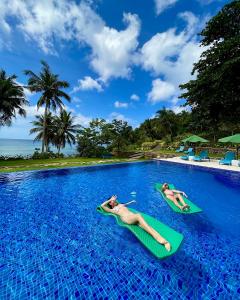 Dos personas colocando tablas de onogie en una piscina en Tuburan Cove Beach Resort en Buruanga