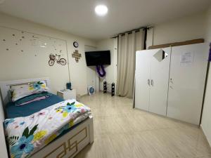 a bedroom with a bed and a tv in it at Private Room Shared Apartment Flat31-R1 in Abu Dhabi