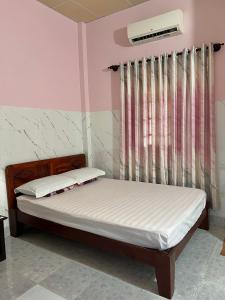 1 dormitorio con cama y ventana en Duc Thao Guest House, en Mui Ne
