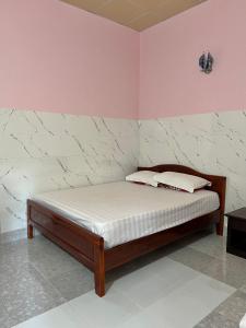 a bed in a room with pink walls at Thao Vi Guest House Duc Thao in Mui Ne +50 photos