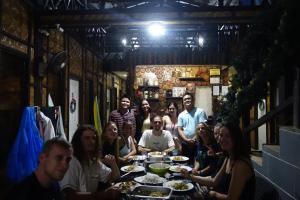盧納將軍城的住宿－Mi Casa Suites Siargao，一群坐在餐桌上吃食物的人