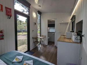 a room with a bed and a kitchen with a counter at Tiny House 22 at Grampians Edge in Dadswells Bridge