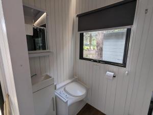 a small bathroom with a toilet and a window at Tiny House 22 at Grampians Edge in Dadswells Bridge