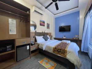 ein Schlafzimmer mit großem Bett und Fernseher in der Unterkunft Casa Marco Suites Puerto Galera powered by Cocotel in Puerto Galera