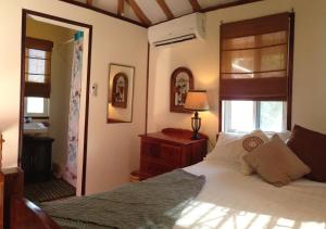 a bedroom with a bed and a window and a mirror at Hummingbirds Cabins in Caye Caulker +55 photos