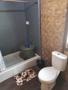 ein Badezimmer mit einem WC und einer Badewanne mit einem Kuhteppich in der Unterkunft Villa panrangluhu in Bira