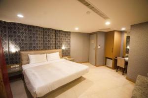 een slaapkamer met een groot wit bed in een kamer bij Love Hotel in Pingtung City