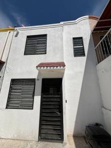 een wit gebouw met een deur en een raam bij Casa con todos los servicios in Concepción del Valle