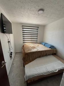 een kleine slaapkamer met een bed en een raam bij Casa con todos los servicios in Concepción del Valle