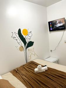 una camera da letto con un letto con un fiore sul muro di Pousada Marajó For You a Soure