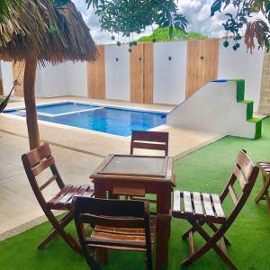 uma mesa e cadeiras ao lado de uma piscina em CABAÑA LUJOSA CON MESA DE BILLAR em Sabanagrande