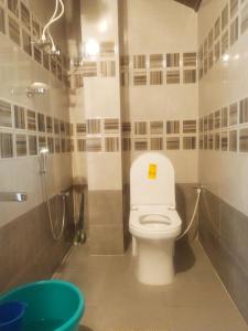 La salle de bains est pourvue de toilettes, d'une douche et d'une baignoire. dans l'établissement The two bedroom homestay, à Madikeri
