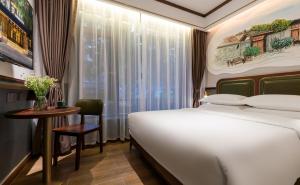 1 dormitorio con cama, mesa y ventana en 时光漫步S酒店（成都宽窄巷子店） en Chengdú